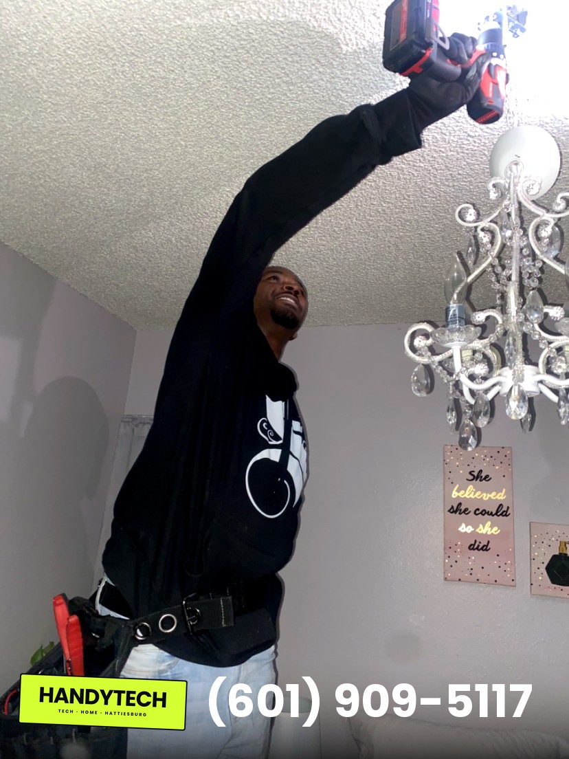 HandyTech LLC Hattiesburg owner installing a chandelier light fixture